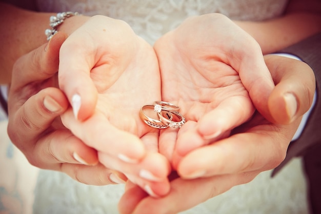 Manos y anillos en ramo de boda