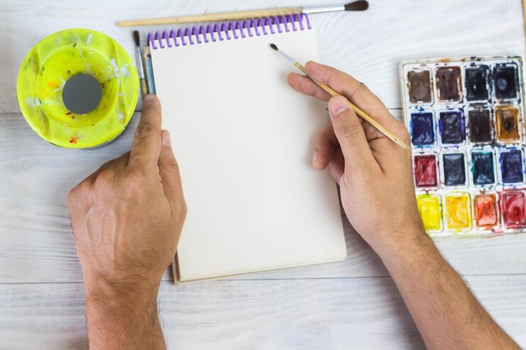Foto las manos del artista pintan pinceles de paleta de diferentes colores el hombre está dibujando las herramientas del artista para el arte real y la inspiración vista superior
