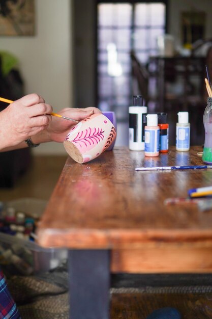 Foto manos de una artista pintando un típico té mate argentino.