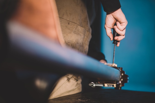 Foto manos de barnizado artesano luthier, construyendo un contrabajo