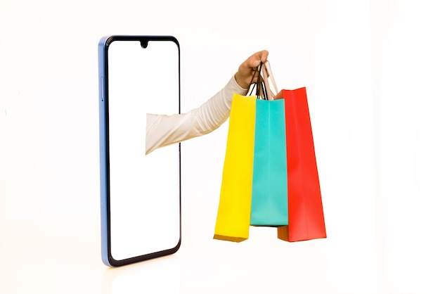 Manos con bolsas de papel extendidas desde la pantalla del teléfono celular hacia el espacio de copia fondo blanco aislado Imagen creativa para el concepto de aplicación móvil de servicio de entrega