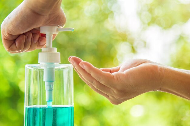 Foto manos cercanas hombre bombeando un gel de alcohol en una botella para proteger la infección de un covid-19