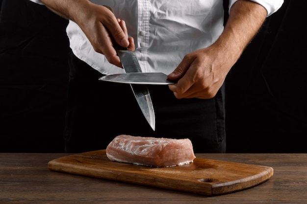 Las manos del chef afilan un cuchillo de cocina