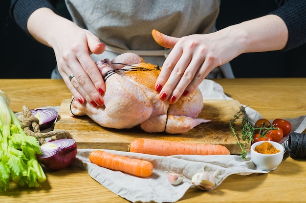 Foto las manos del chef frotaron el pollo crudo con especias.