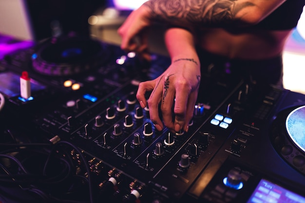 Las manos de una chica dj en el panel de control de música.