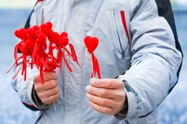 A En manos de un chico un corazón en invierno en la carretera en el fondo de viaje del parque