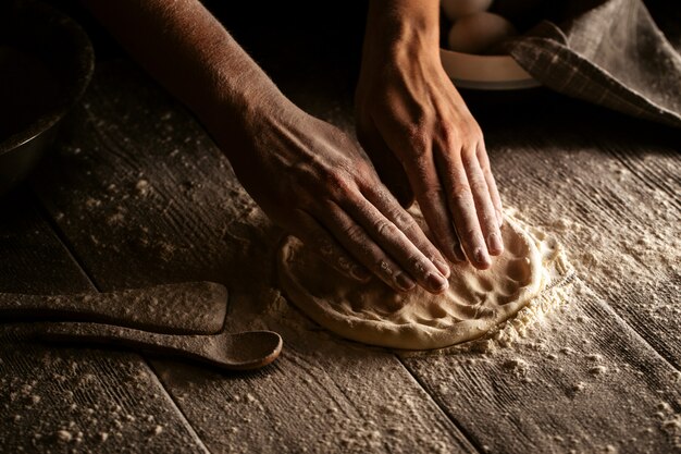 Manos cocinando masa en torta plana