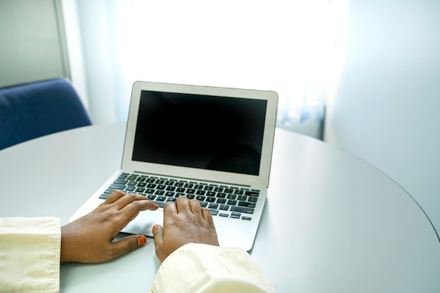 Manos en la computadora portátil con pantalla negra para texto