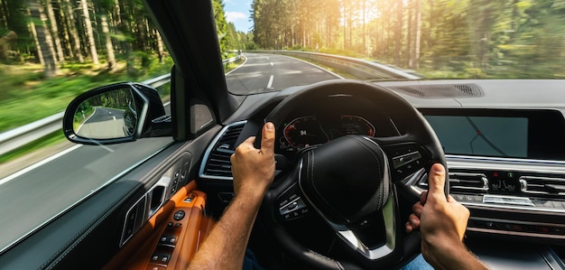 Foto manos del conductor del automóvil en el volante, viaje por carretera, conducción en carretera