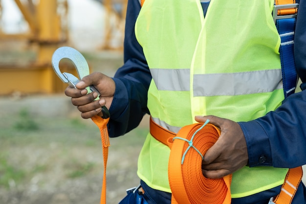 Manos de constructor africano preparando equipos de seguridad antes del trabajo