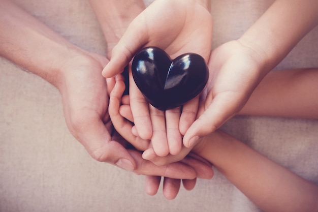 Manos y corazón rojo, seguro de salud.