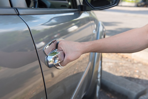 Manos cortadas abriendo la puerta del coche