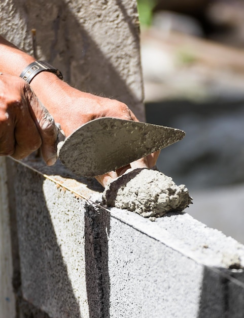 Foto manos cortadas de un albañil trabajando en un sitio de construcción