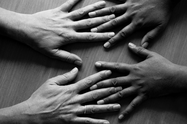 Manos cortadas de amigos en la mesa