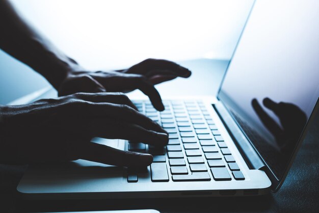 Manos cortadas con una computadora portátil