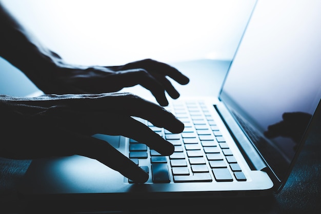 Manos cortadas con una computadora portátil