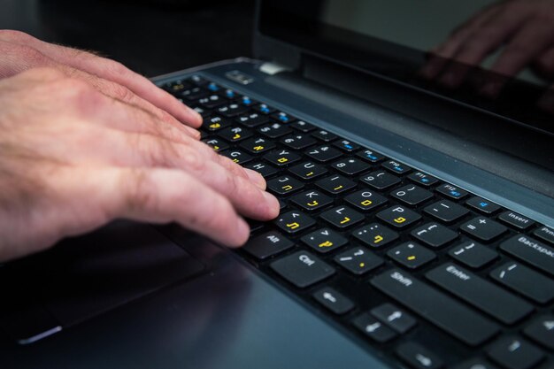 Manos cortadas con una computadora portátil