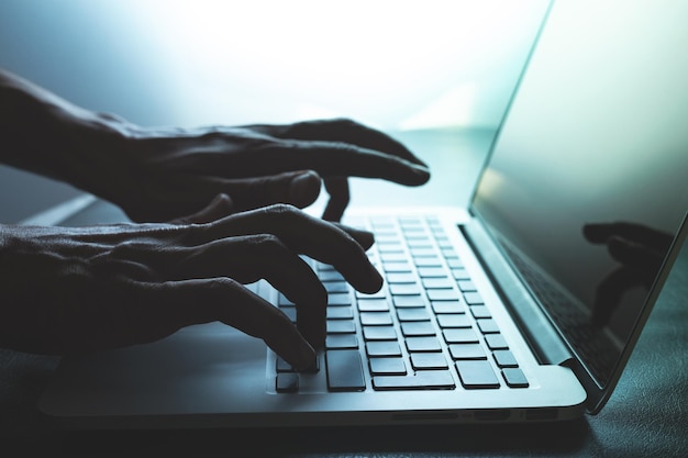 Manos cortadas con una computadora portátil