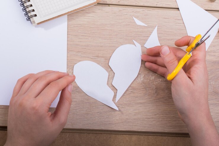 Foto manos cortadas cortando forma de corazón en madera