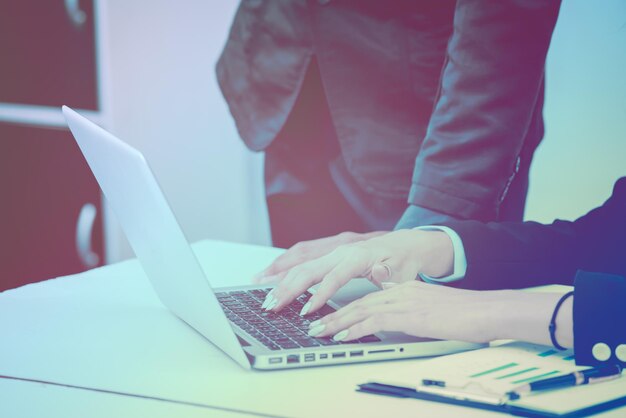 Manos cortadas de un empresario usando una computadora portátil por un empresario en la oficina
