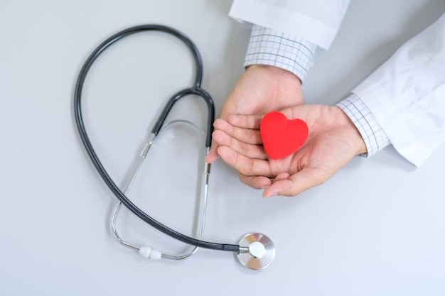 Manos cortadas con forma de corazón rojo en la mesa