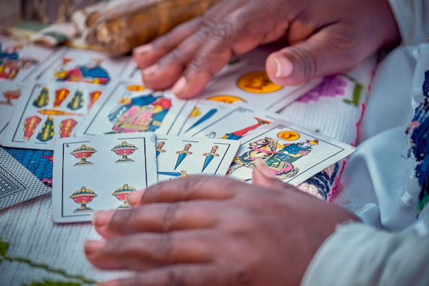 Foto manos cortadas de un hombre con cartas en la mesa.