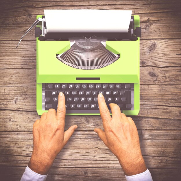 Foto manos cortadas de un hombre escribiendo en una máquina de escribir en la mesa