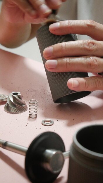 Foto manos cortadas de un hombre limpiando un molinillo de café manual