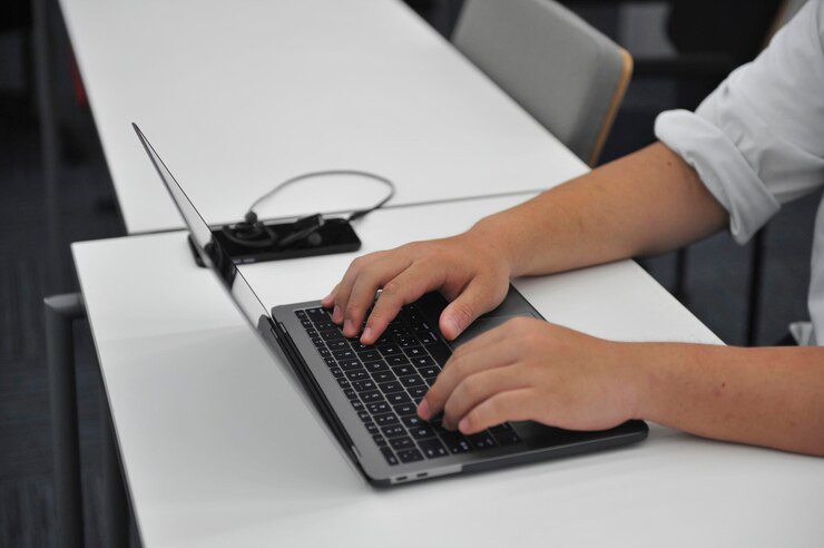 Foto manos cortadas de un hombre de negocios usando una computadora portátil en el escritorio