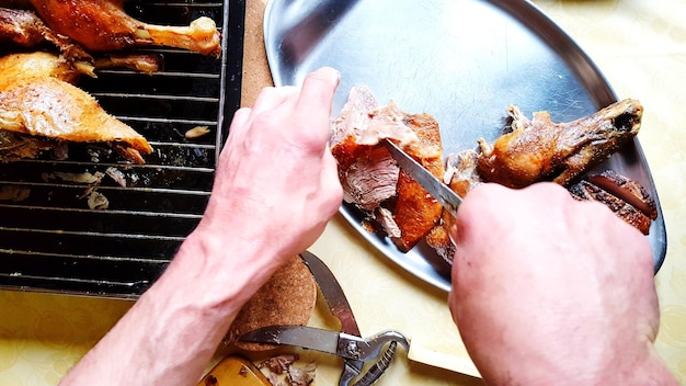 Foto manos cortadas de un hombre preparando carne en la mesa