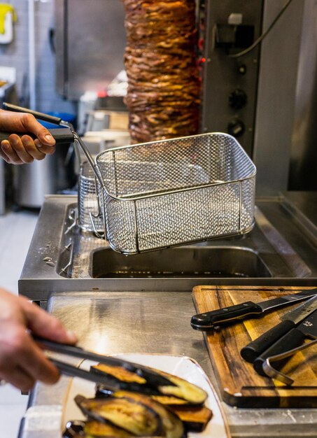 Manos cortadas de un hombre preparando comida en la cocina