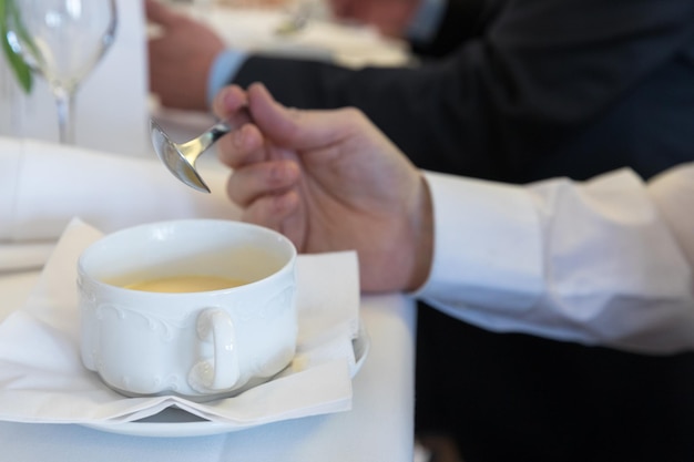 Manos cortadas de un hombre con sopa en la mesa en un restaurante