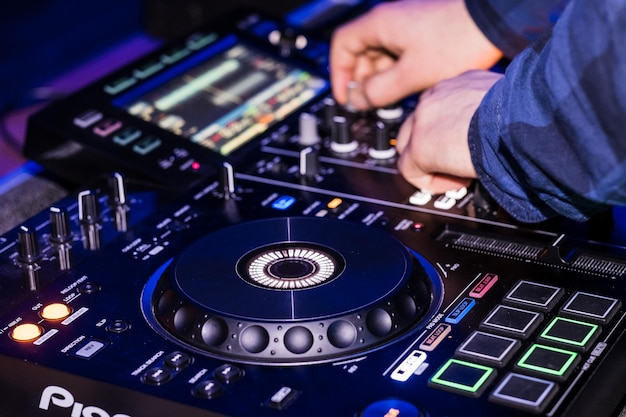 Manos cortadas de un hombre tocando equipo de audio