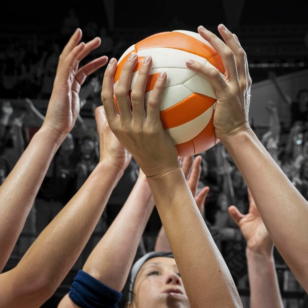 Manos cortadas de jugadores practicando voleibol