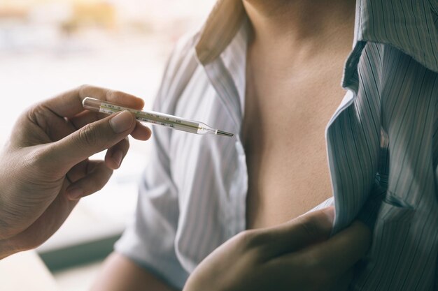 Foto manos cortadas de un médico que examina a un paciente masculino en un hospital