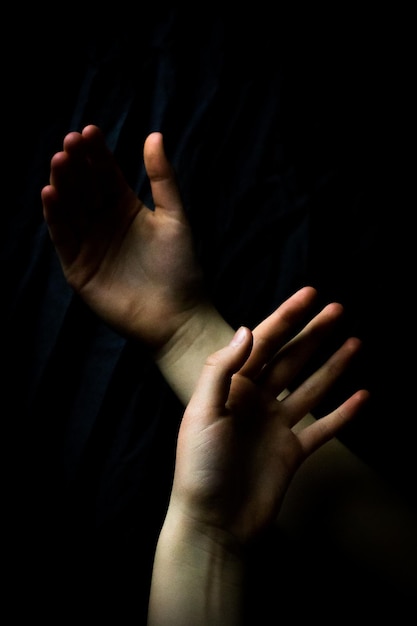 Manos cortadas de una mujer contra un fondo negro
