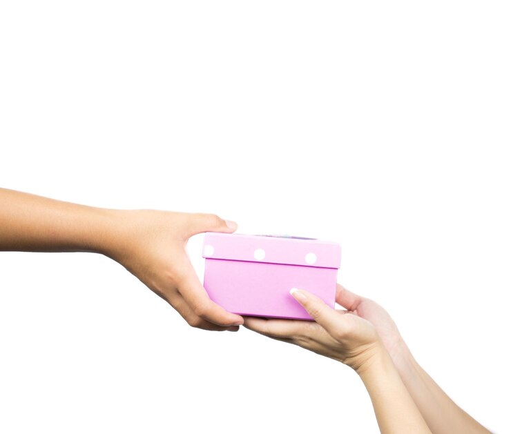 Foto manos cortadas de una mujer dando un regalo de navidad a una amiga contra un fondo blanco