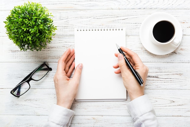 Manos cortadas de una mujer escribiendo en un libro