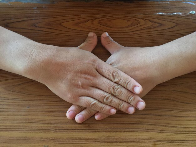 Foto manos cortadas de una mujer en una mesa de madera