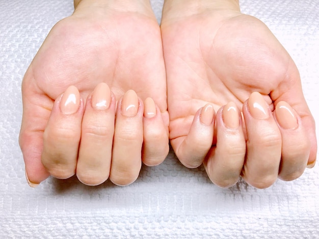 Manos cortadas de una mujer mostrando sus uñas pintadas