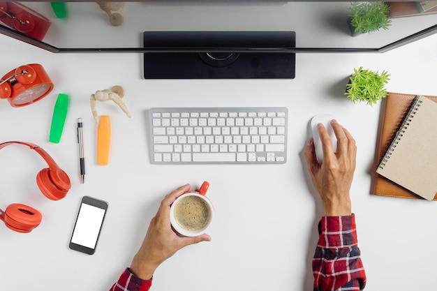Manos cortadas de una mujer de negocios usando una computadora en el escritorio de la oficina