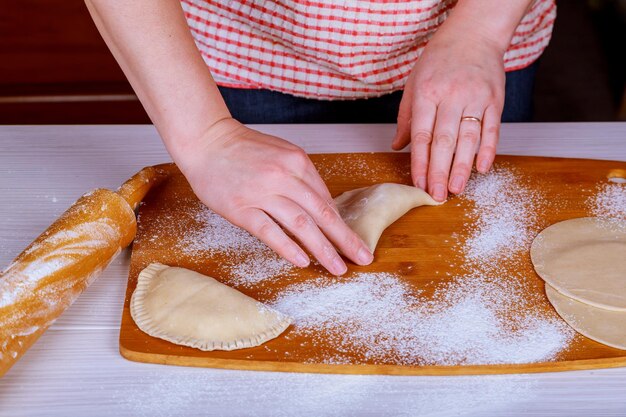 Foto manos cortadas de una mujer preparando comida en la tabla de cortar