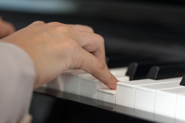 Foto manos cortadas de una mujer tocando el piano