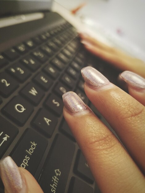Foto manos cortadas de una mujer usando una computadora portátil
