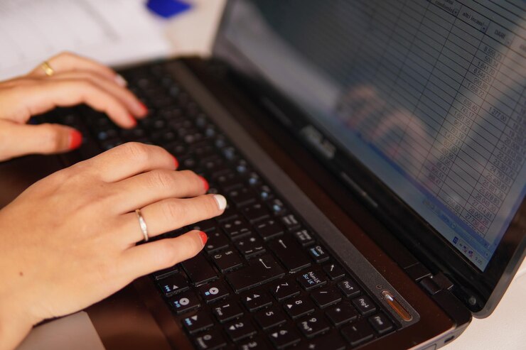 Foto manos cortadas de una mujer usando una computadora portátil