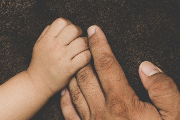 Foto manos cortadas de niño y padre en una manta