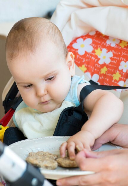 Foto manos cortadas de padres alimentando a su hija en la cama