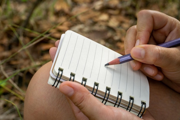 Foto manos cortadas de una persona escribiendo en un diario