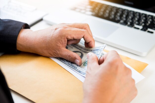 Foto manos cortadas de una persona de negocios contando dinero en el escritorio de la oficina