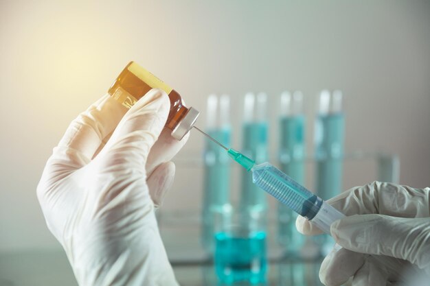 Manos cortadas de la persona que prepara la inyección en el laboratorio